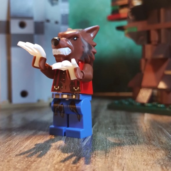 Eine Legofigur eines Werwolfs vor einem Baum und einer Ruine